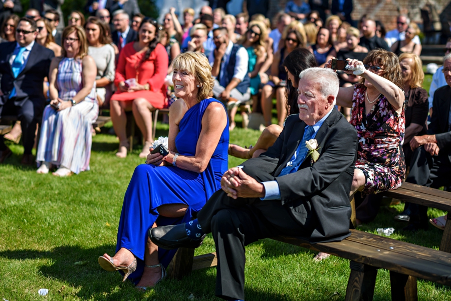 Two parents watching their daughter's wedding during the ceremony.